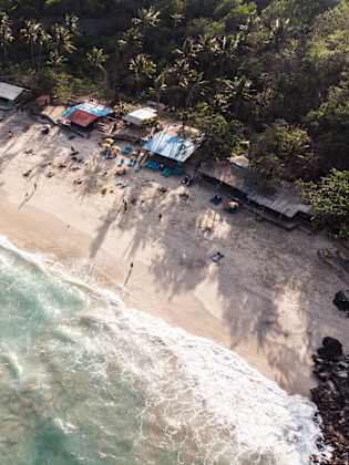 Ein Strand an einem Wald mit kleinen Holzgebäuden